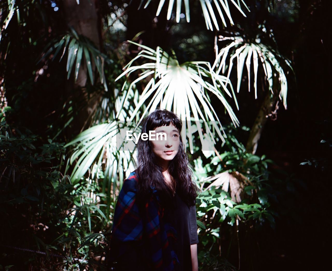 PORTRAIT OF SMILING YOUNG WOMAN IN PARK