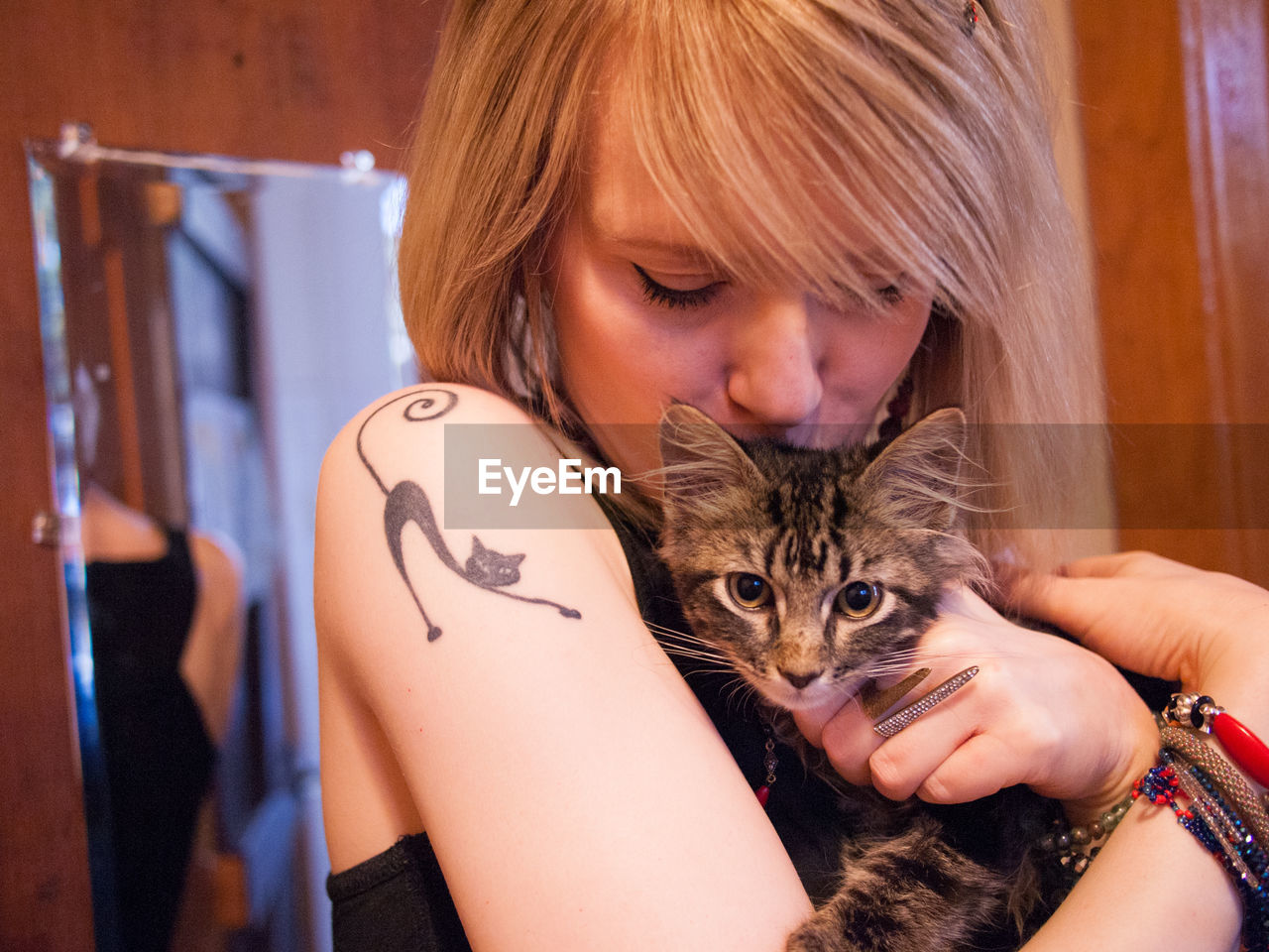 Close-up of woman kissing cat at home