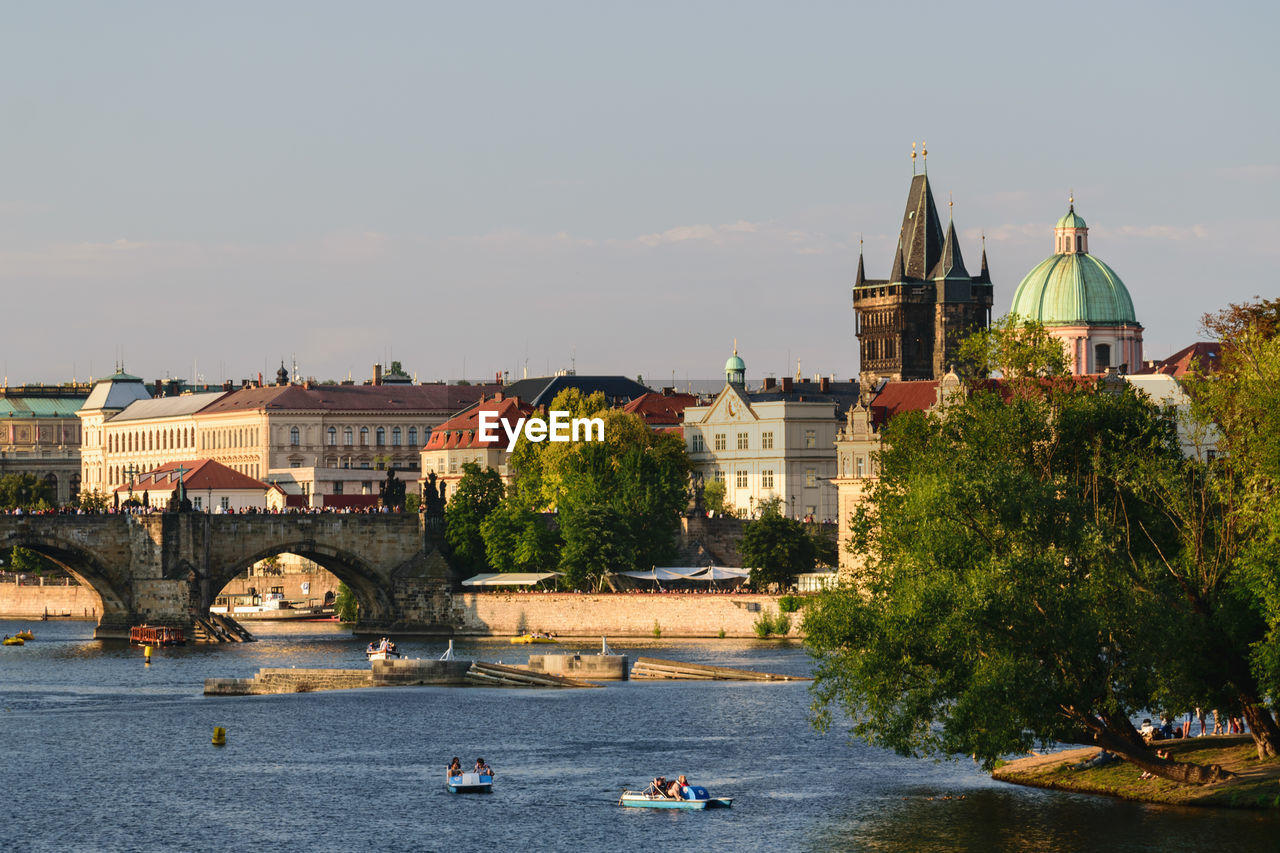 BUILDINGS BY RIVER AGAINST SKY