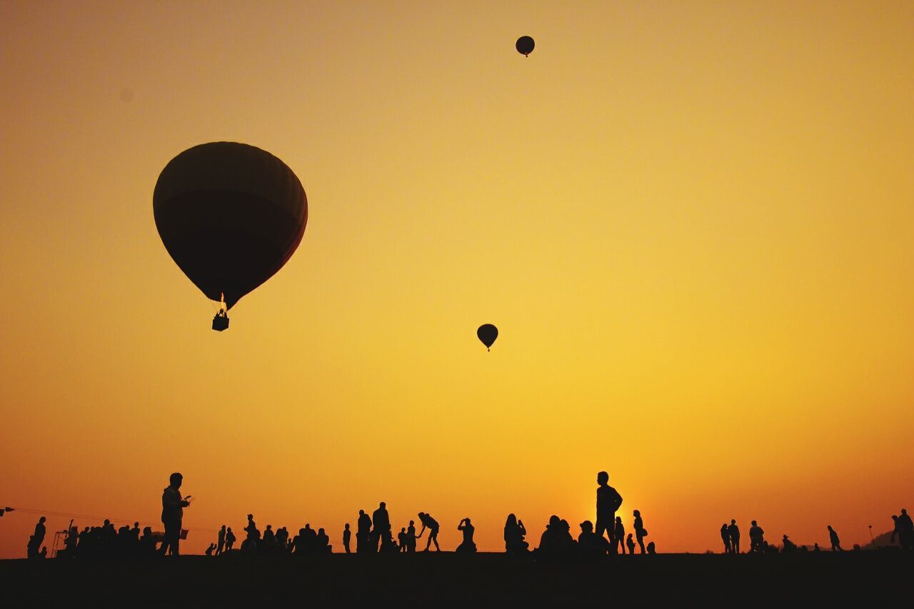 Low angle view of hot air balloons flying over landscape
