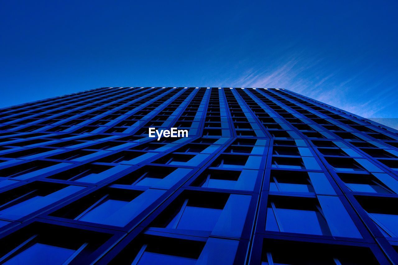 Low angle view of modern building against blue sky