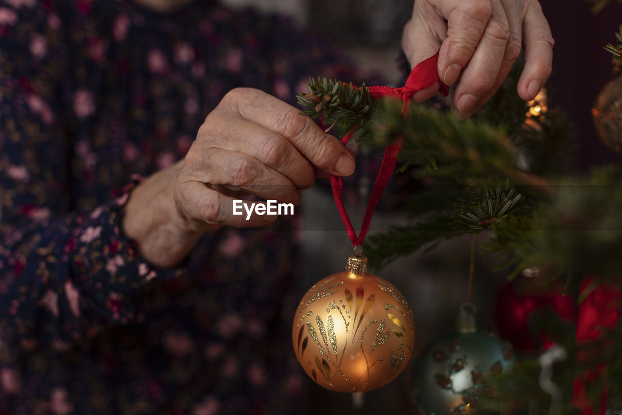 Woman's hands decorating christmas tree