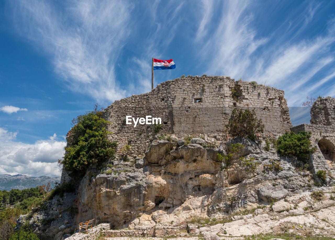 LOW ANGLE VIEW OF FLAG ON MOUNTAIN