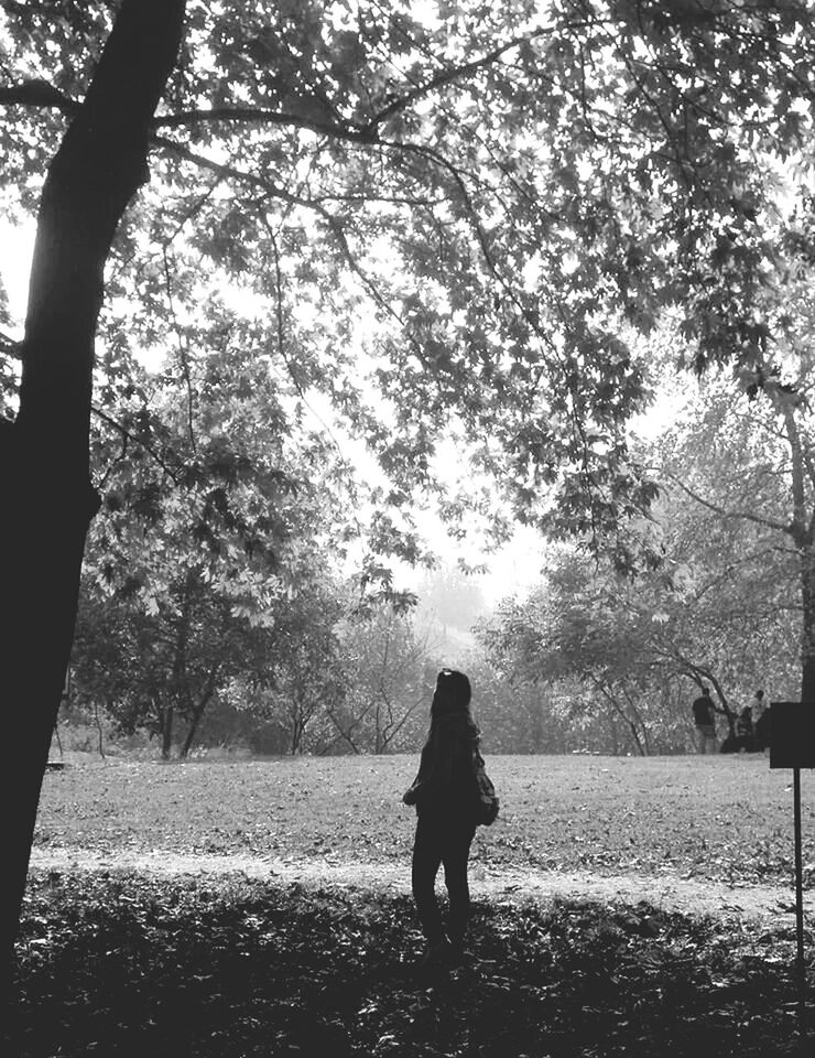 Woman standing against tree on field