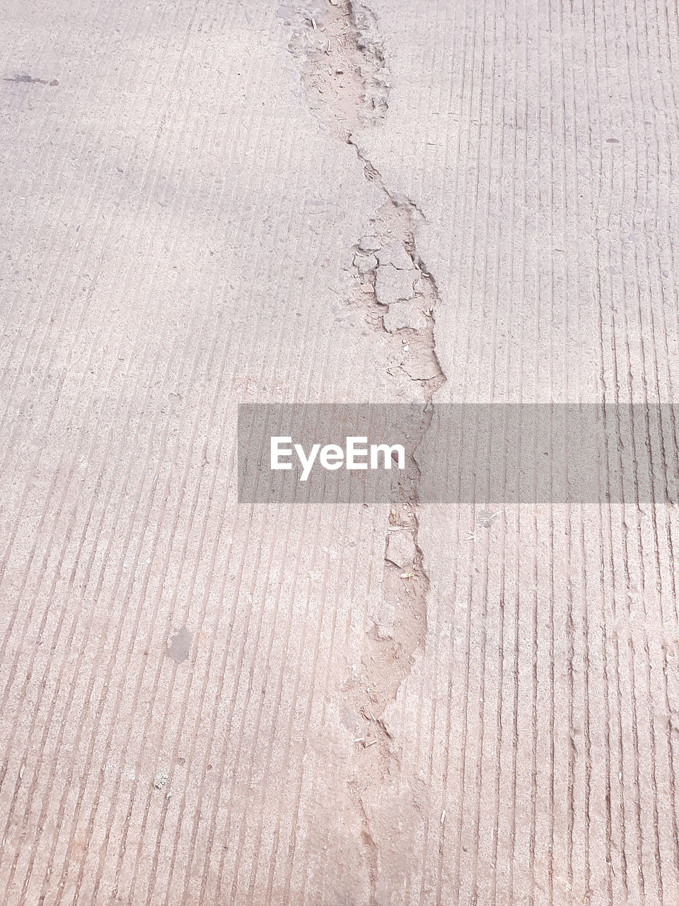  a broken asphalt road with line pattern in the background