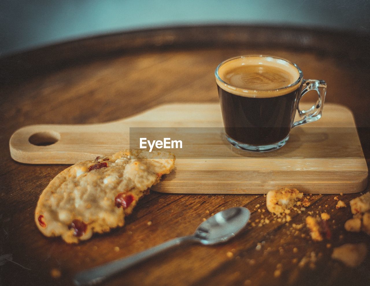 Close-up of coffee cup and cookie on serving board