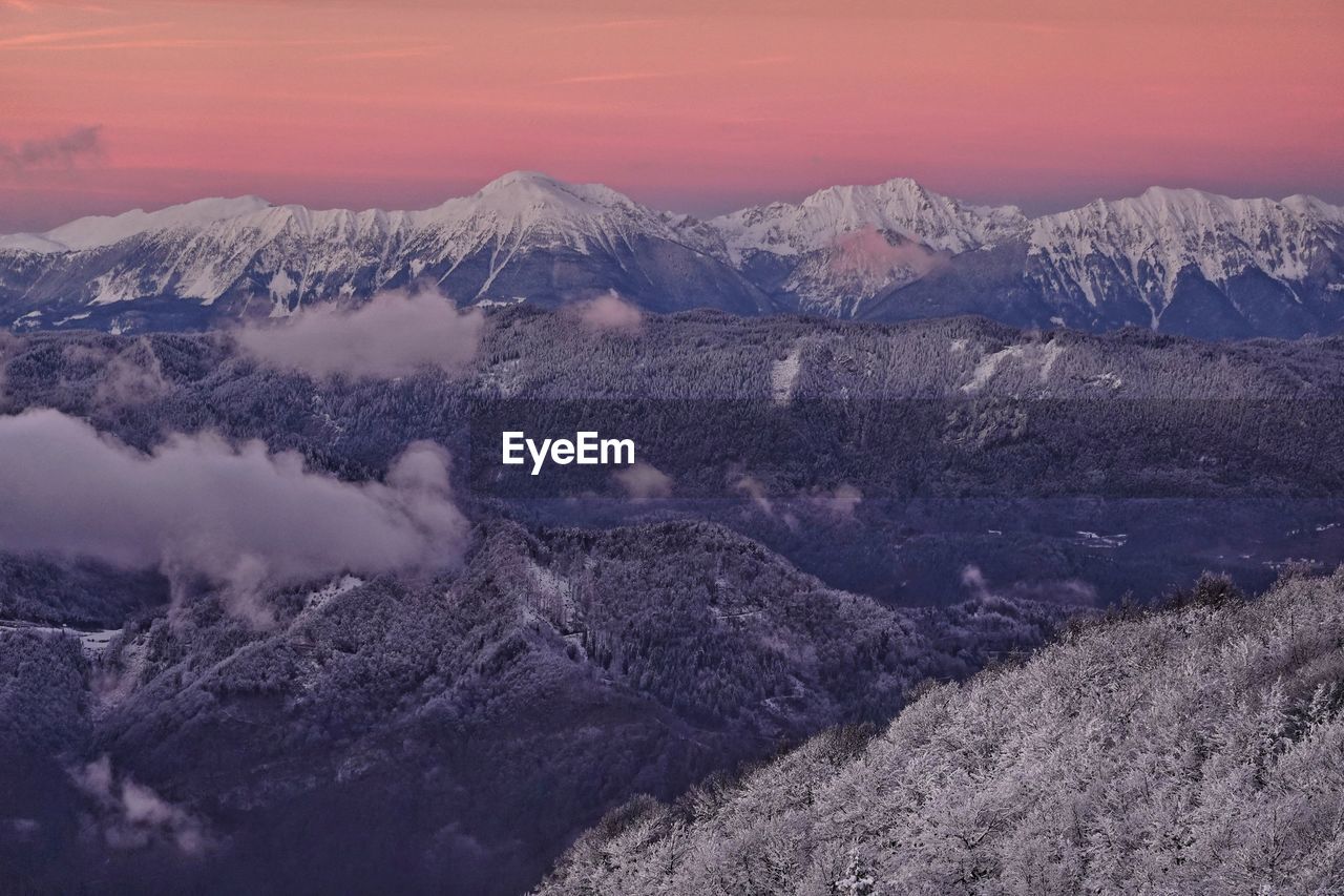 Scenic view of snowcapped mountains against sky during sunset