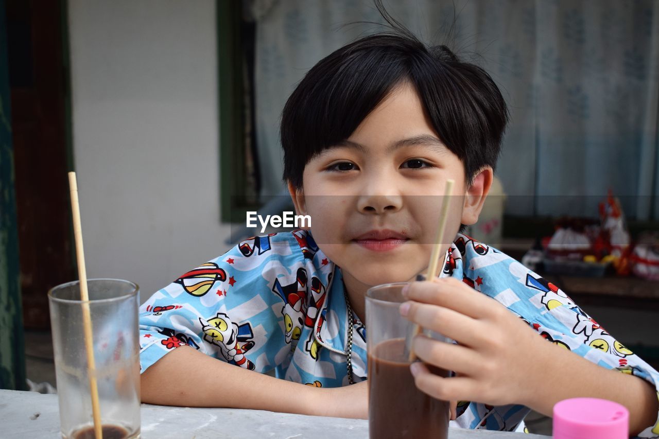 Portrait of boy having chocolate drink at home