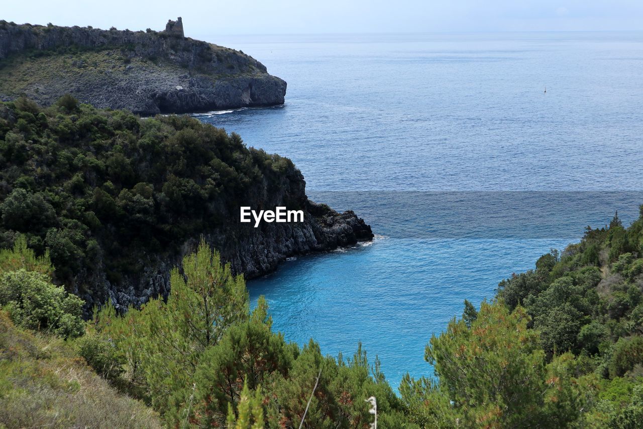 SCENIC VIEW OF SEA BY ROCKS AGAINST SKY