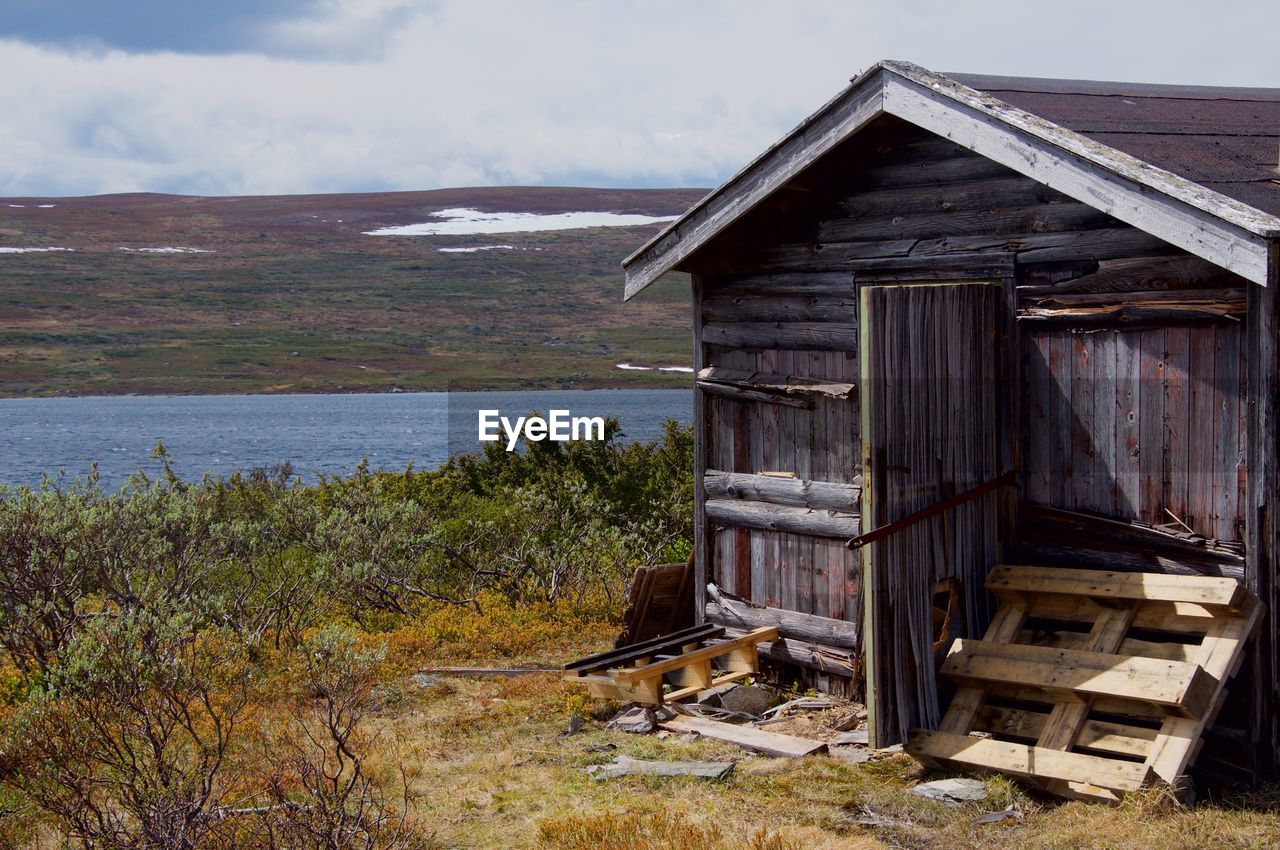 ABANDONED WOODEN COTTAGE BY LAKE