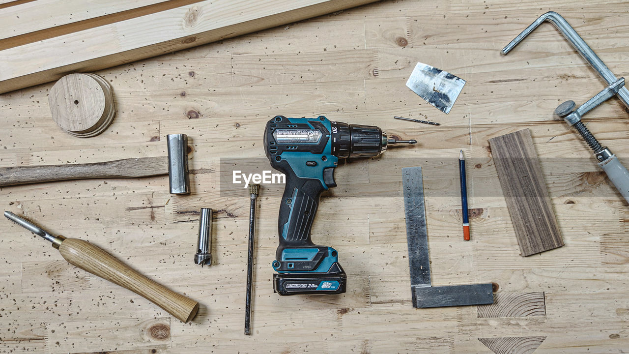 HIGH ANGLE VIEW OF TOOLS ON WOODEN TABLE