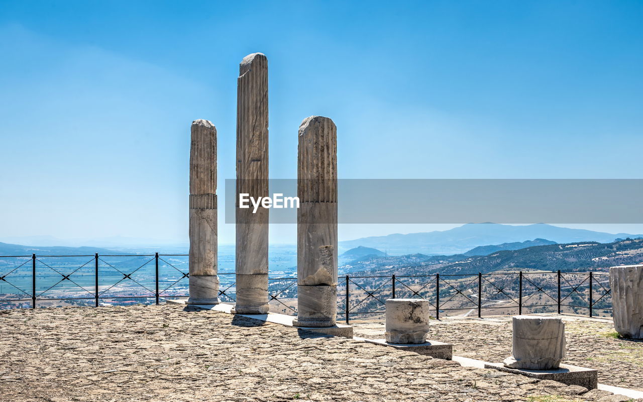 WOODEN POSTS AT BEACH AGAINST SKY