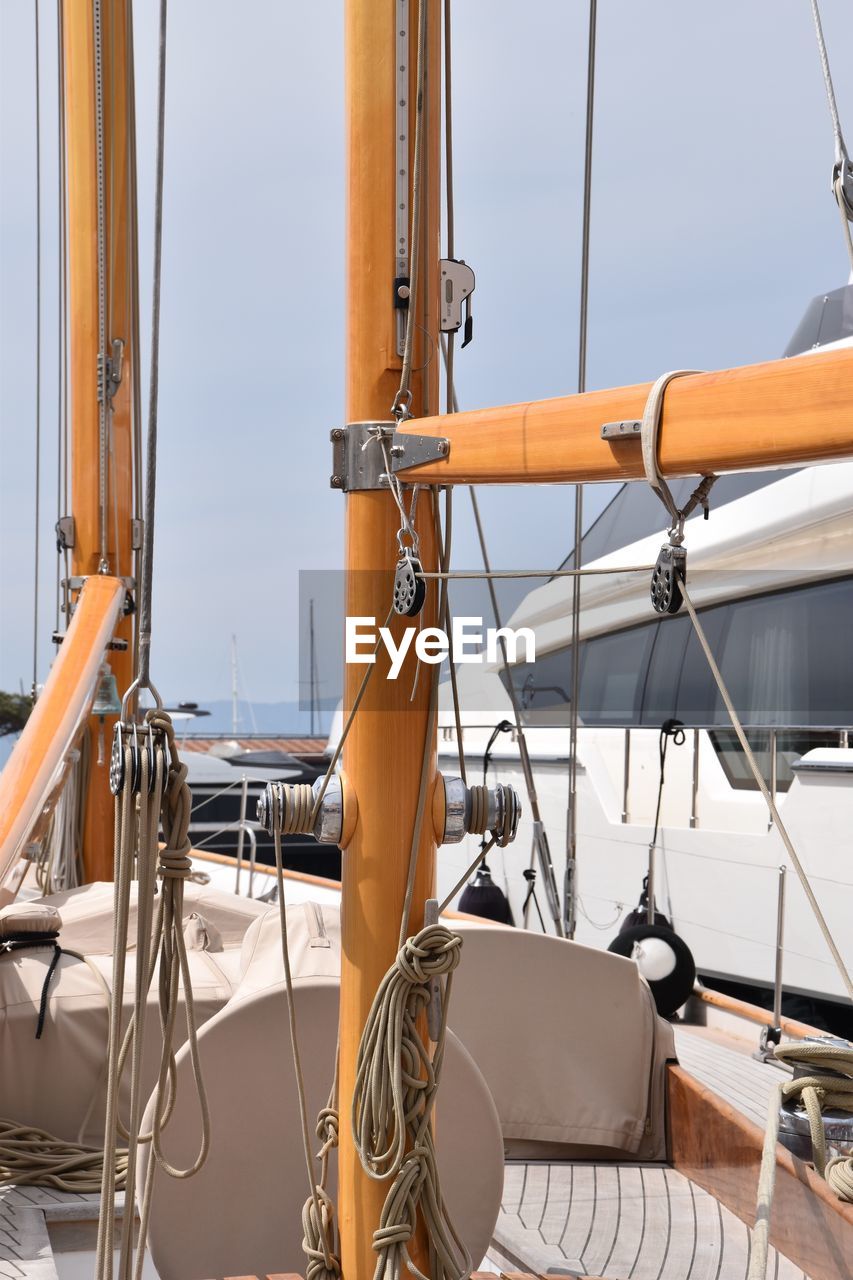 Sailboats moored in sea against sky