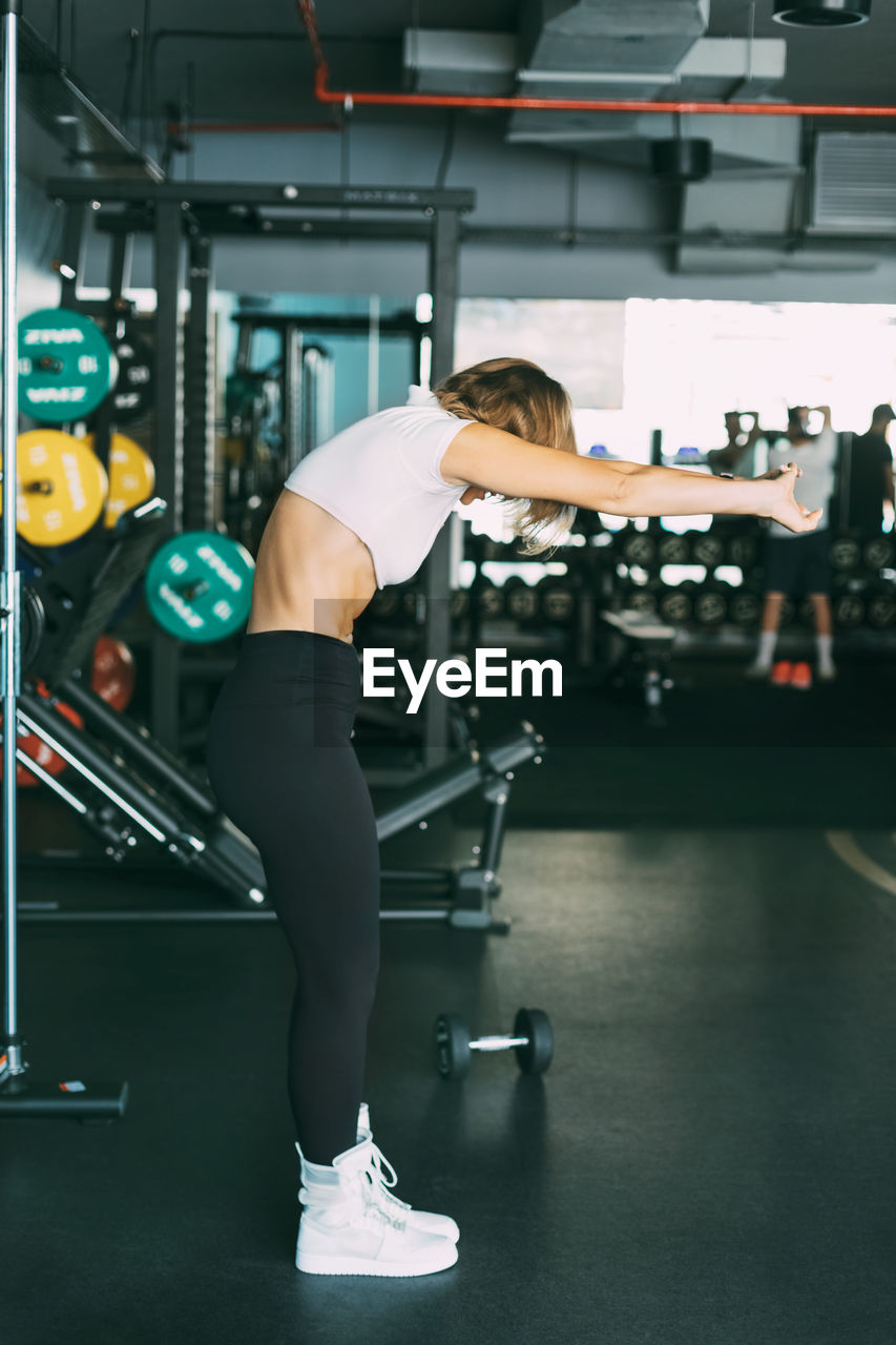 An active girl does stretching exercises after a workout in the gym. sports, fitness