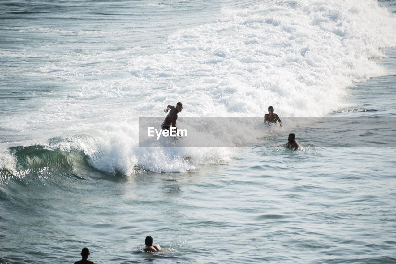 People bathing in the water at paciencia beach in salvador, bahia, brazil.