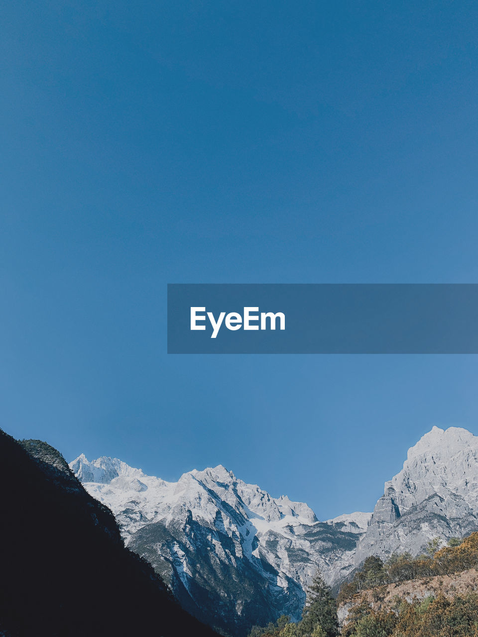 Scenic view of snowcapped mountains against clear blue sky