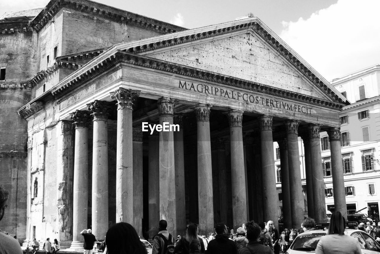 People walking in front of pantheon in city