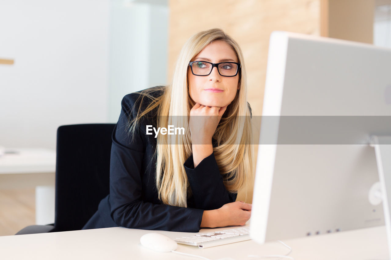 Woman sitting by desktop