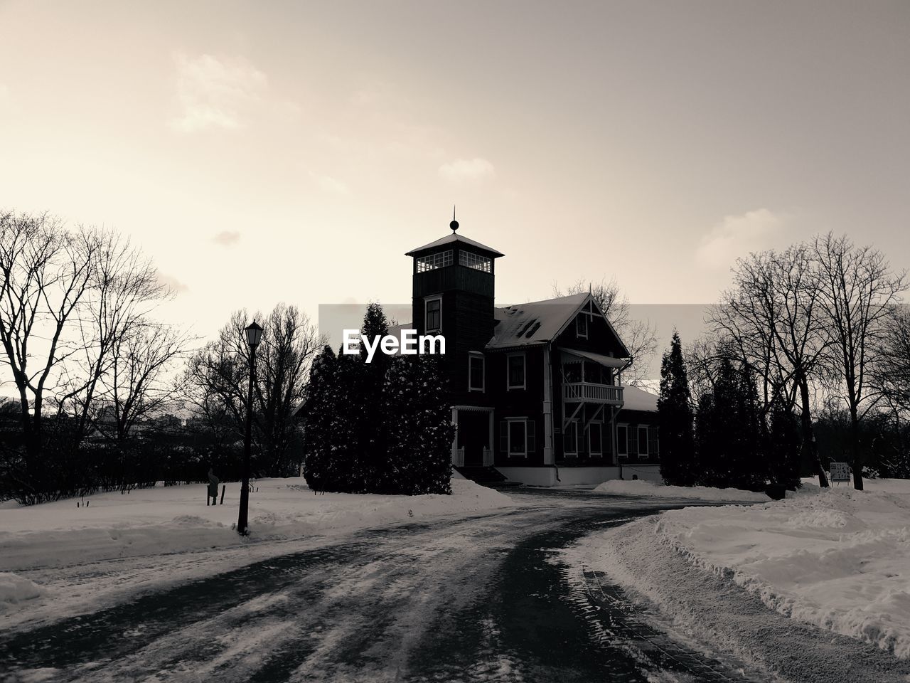 HOUSES BY ROAD AGAINST SKY DURING WINTER