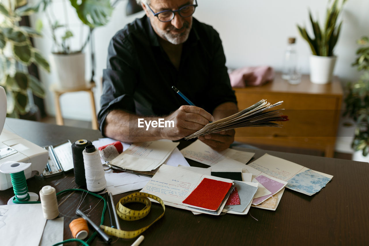 Male costume designer working at table in studio