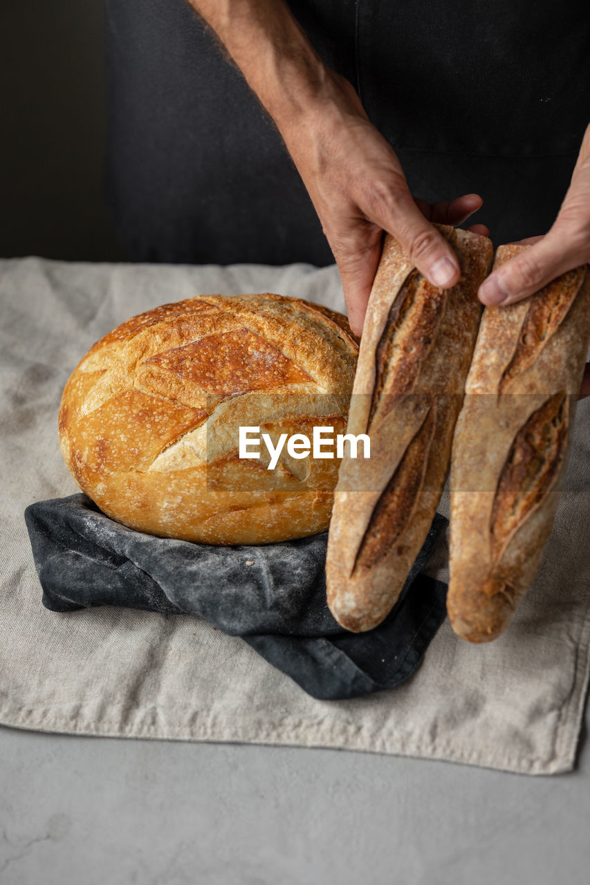 HIGH ANGLE VIEW OF HAND HOLDING BREAD