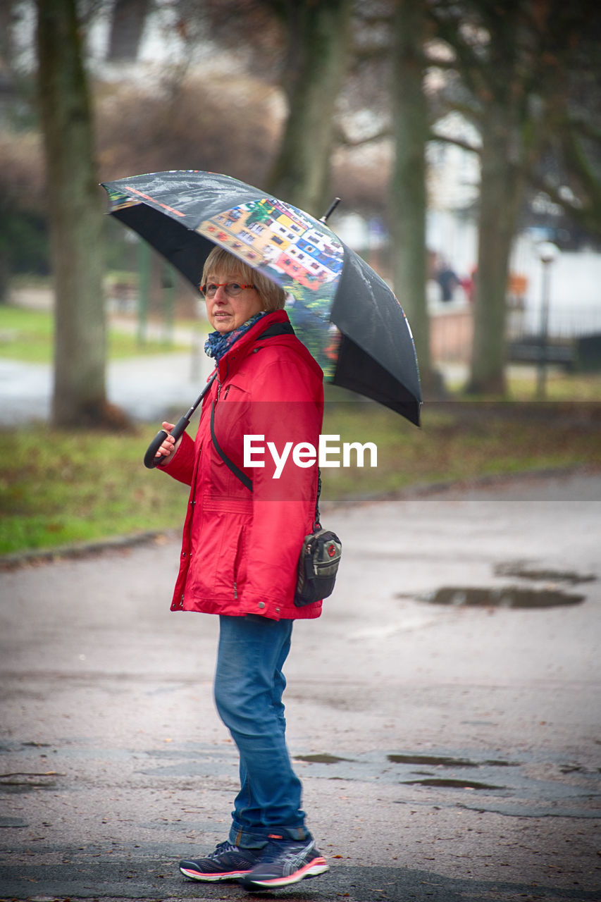 FULL LENGTH OF WOMAN STANDING IN RAIN