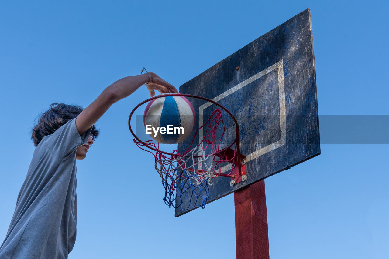 Low angle view of basketball hoop against blue sky