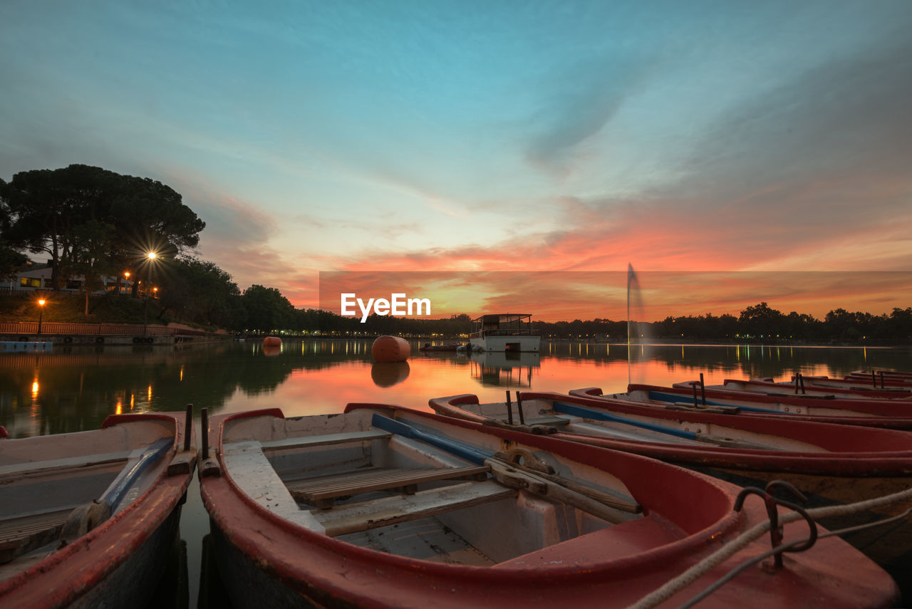 BOATS MOORED AT MARINA DURING SUNSET