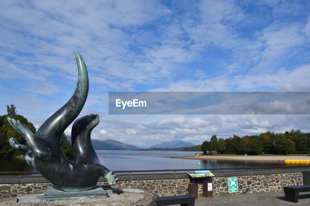 water, sky, cloud, nature, sculpture, statue, sea, animal, no people, marine mammal, day, animal themes, representation, animal wildlife, travel destinations, animal representation, outdoors, monument, art, travel, beauty in nature, blue, architecture, craft, tree