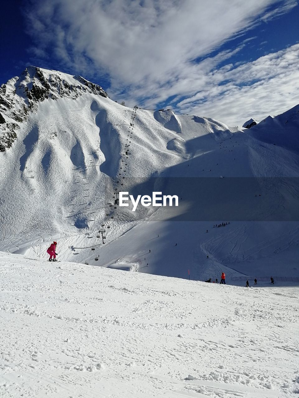 People on snowcapped mountain against sky