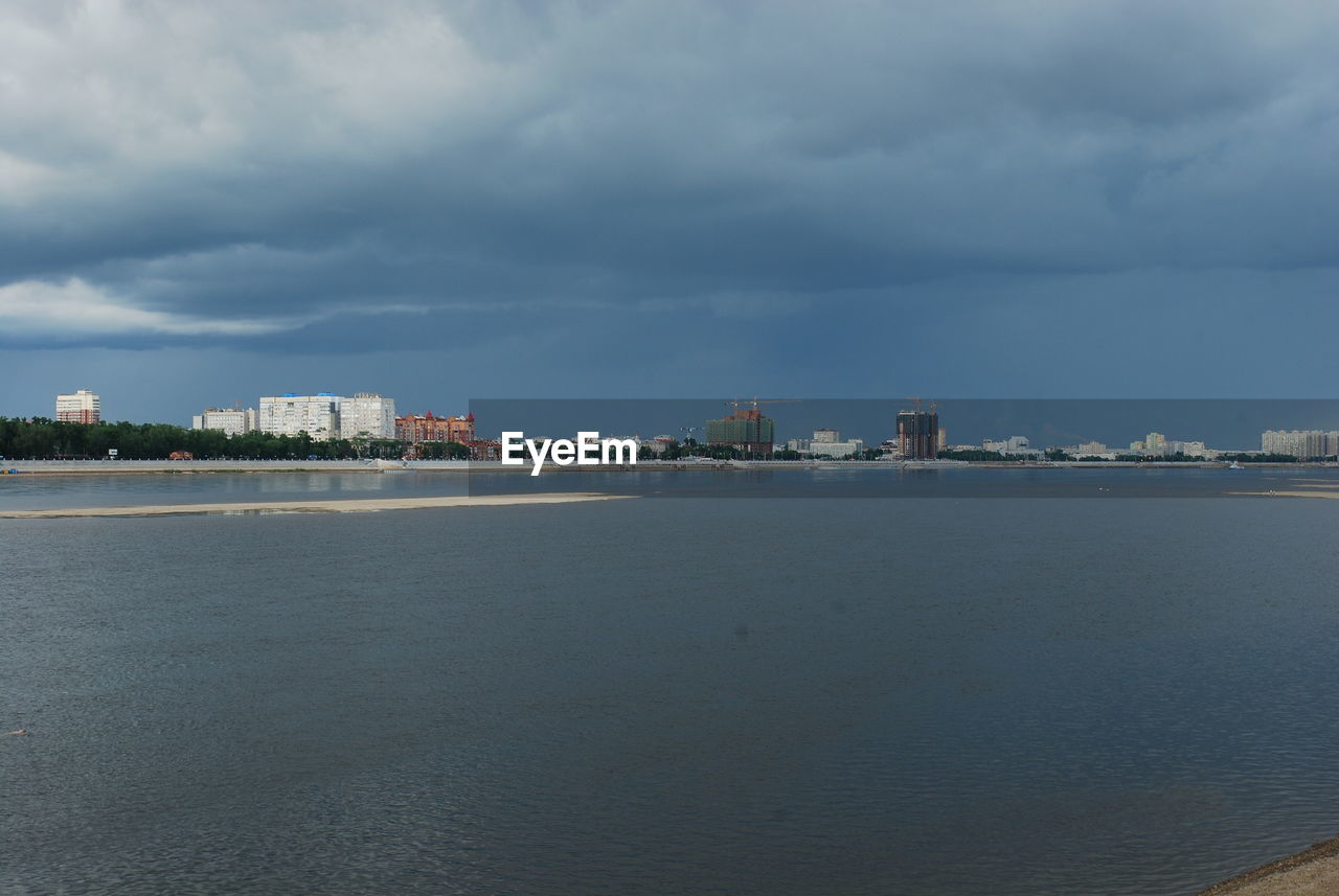 SEA AND BUILDINGS AGAINST SKY