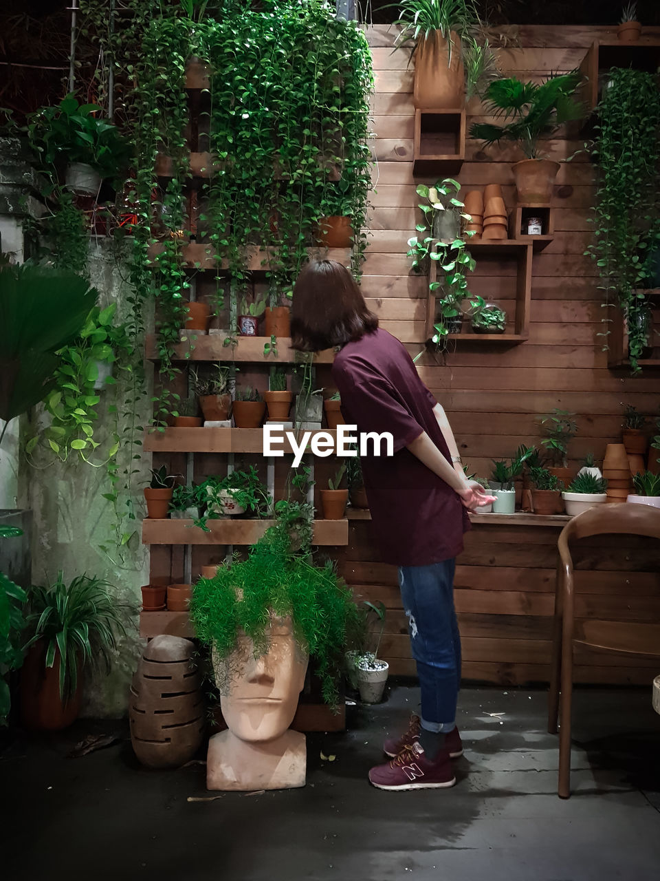 Full length of woman looking at potted plants