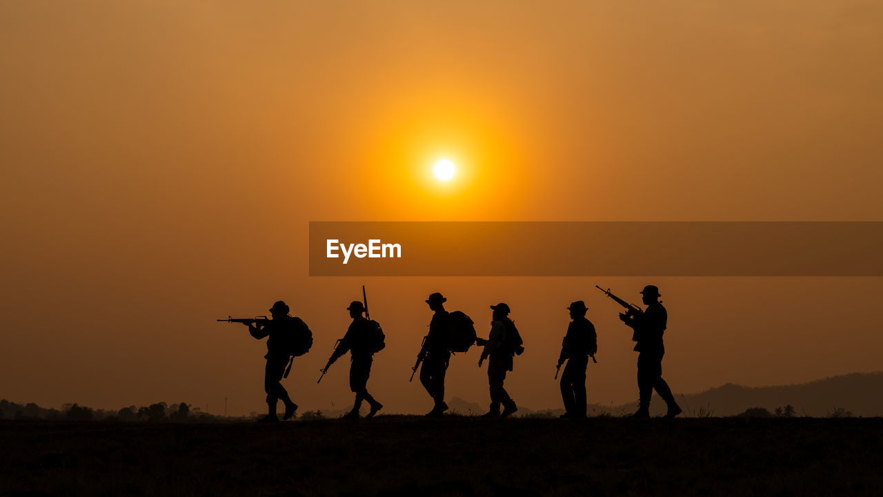 silhouette people at beach during sunset