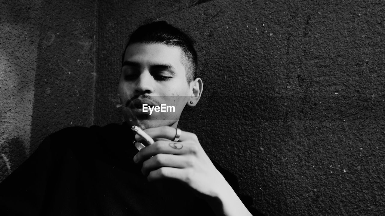 CLOSE-UP OF YOUNG WOMAN SMOKING ON FLOOR