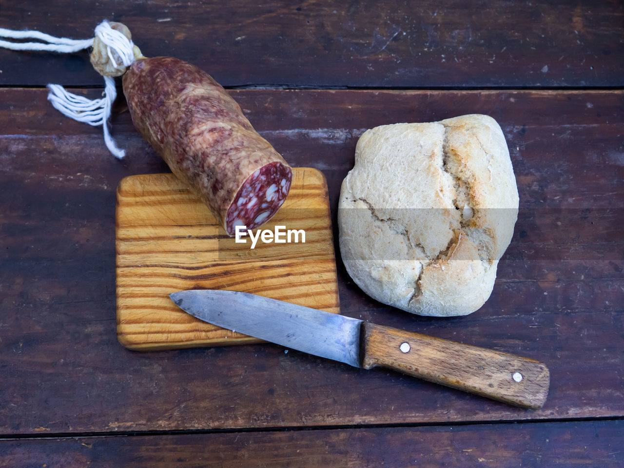 HIGH ANGLE VIEW OF BREAD AND CUTTING BOARD ON TABLE