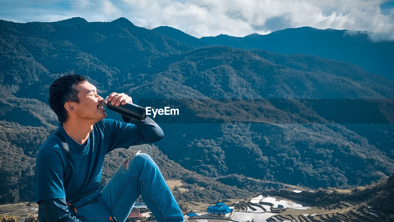 Man photographing against mountains