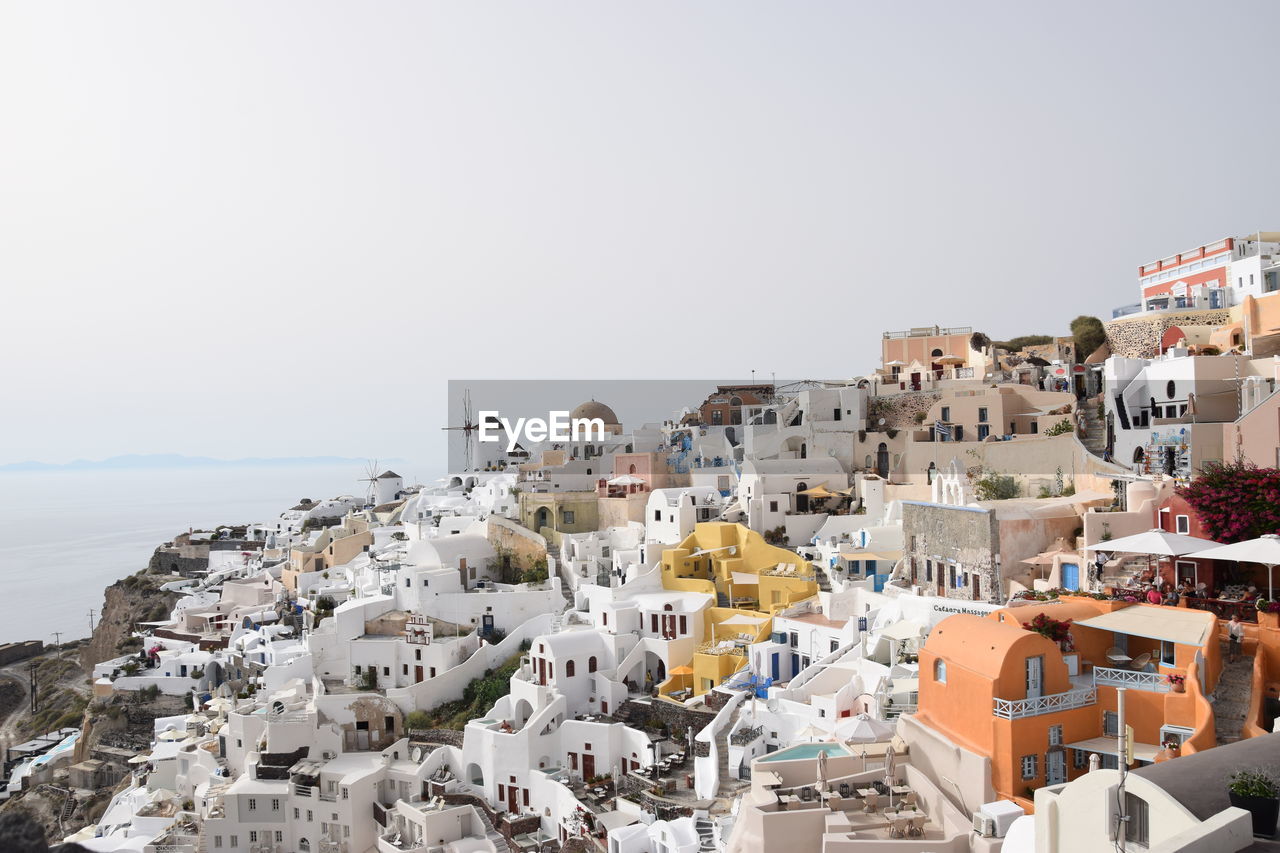 HIGH ANGLE VIEW OF TOWNSCAPE BY SEA AGAINST SKY