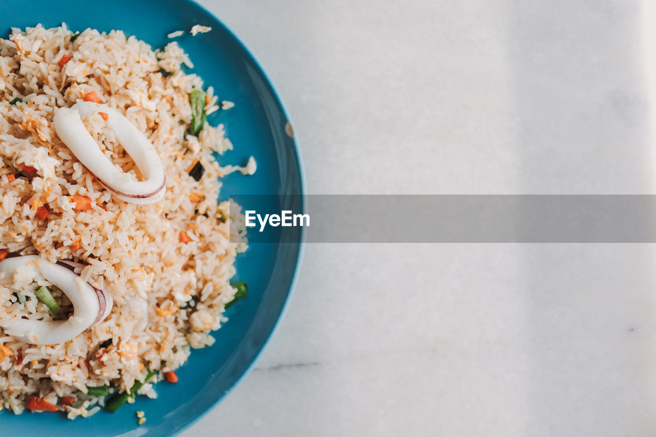 Thai style squid fried rice served in blue ceramic dish.