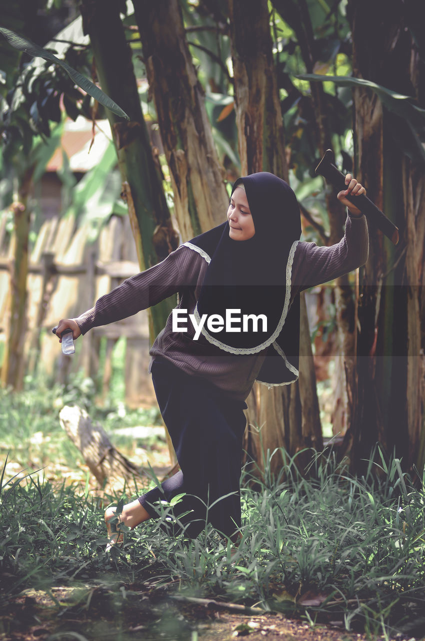 Rear view of woman standing in forest