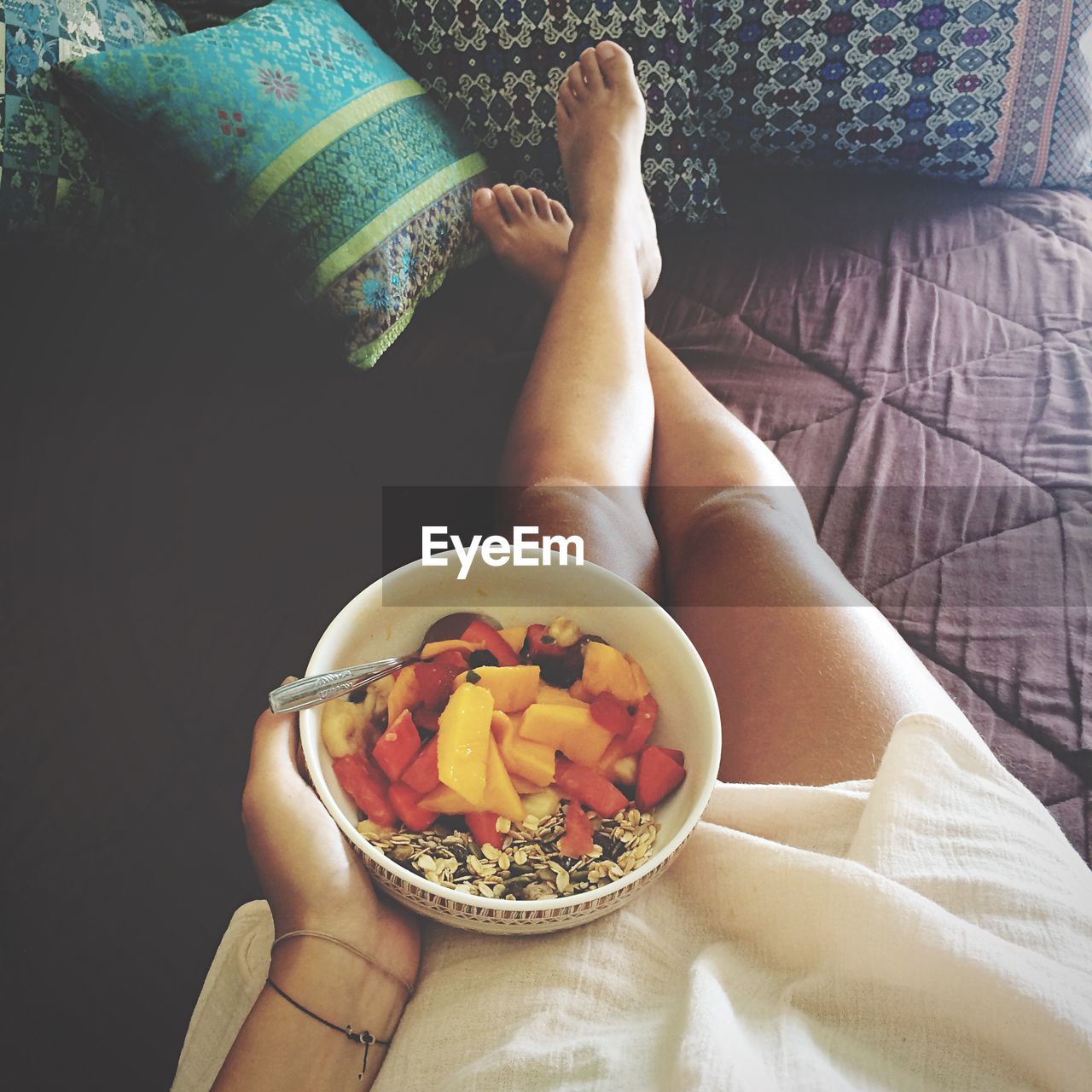 Low section of woman with breakfast relaxing at home