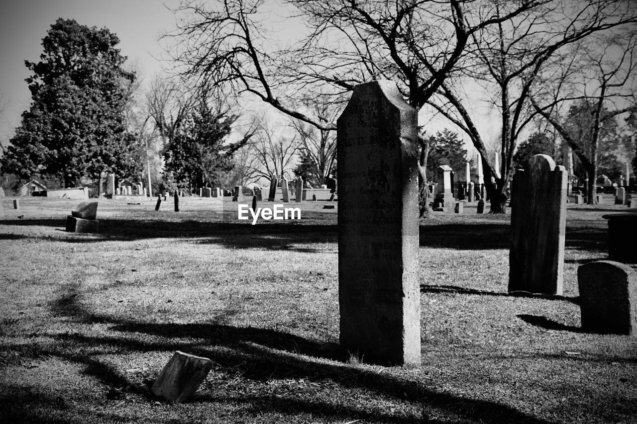 Tombstones at cemetery against sky