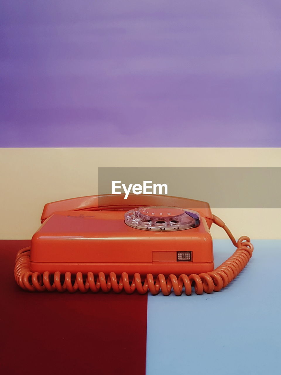 Close-up of telephone against colored background