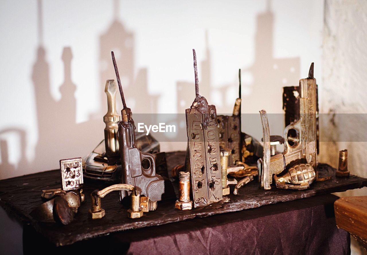 Various objects on table with shadow of city in chocolate museum