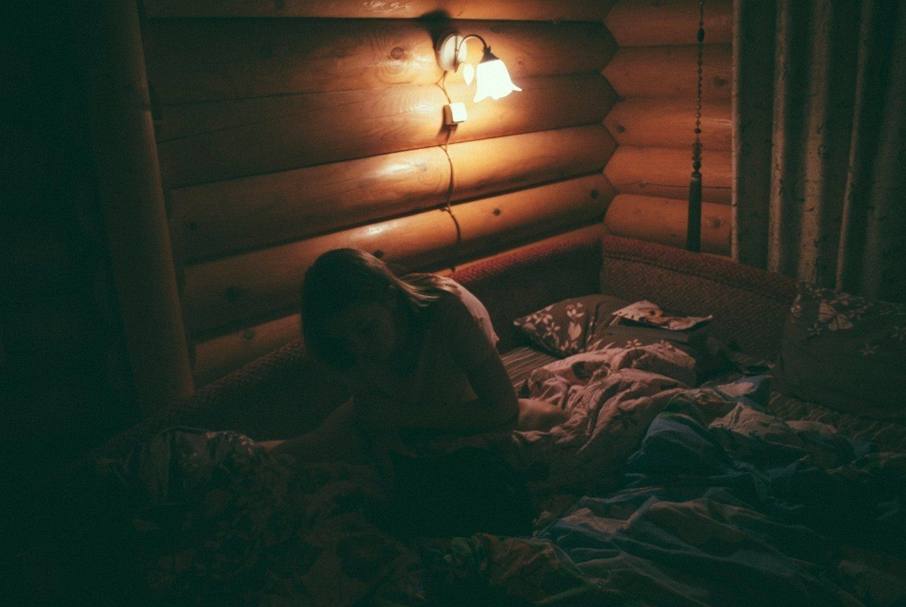 High angle view of woman on bed in illuminated room