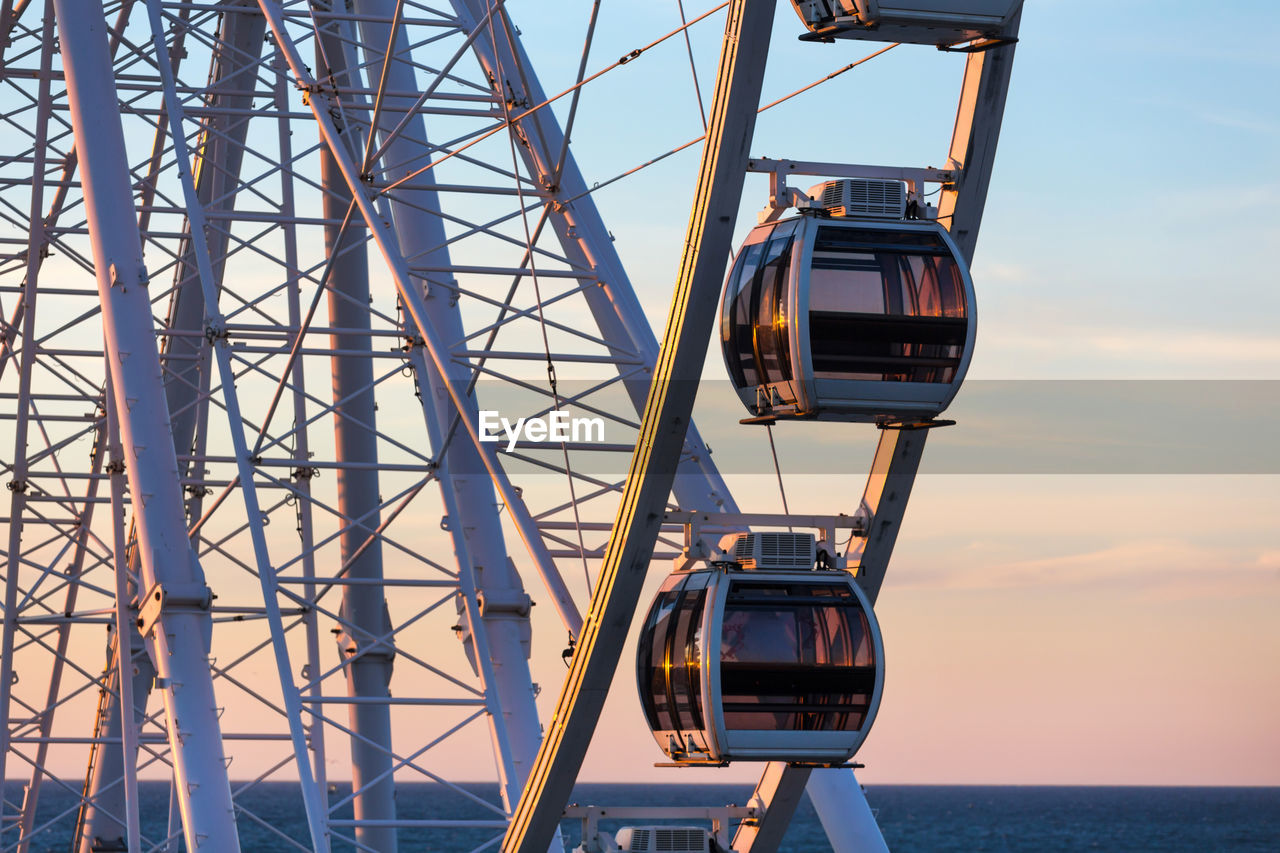 LOW ANGLE VIEW OF FERRIS WHEEL IN SEA AGAINST SKY