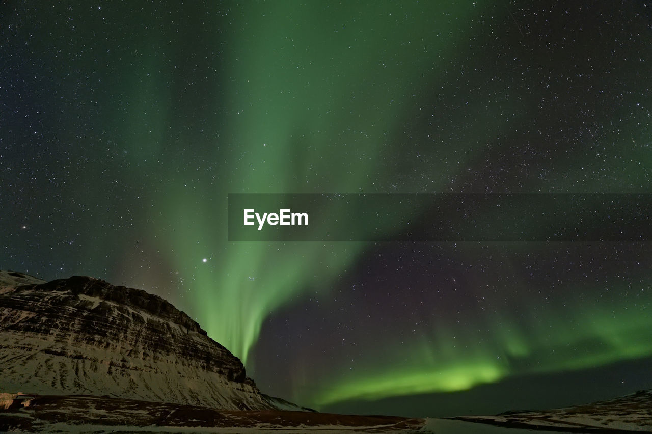 Low angle view of aurora borealis at night during winter