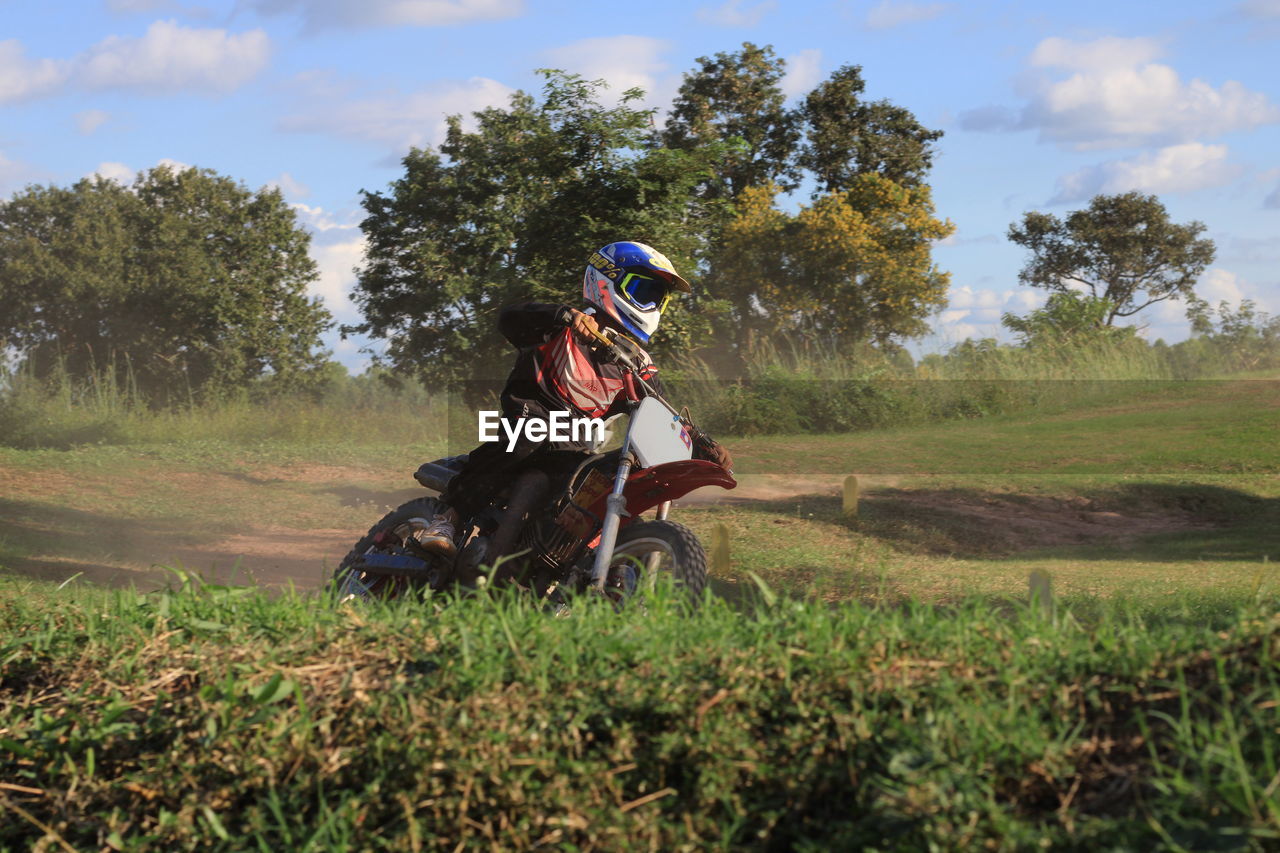 MAN RIDING HORSE ON FIELD