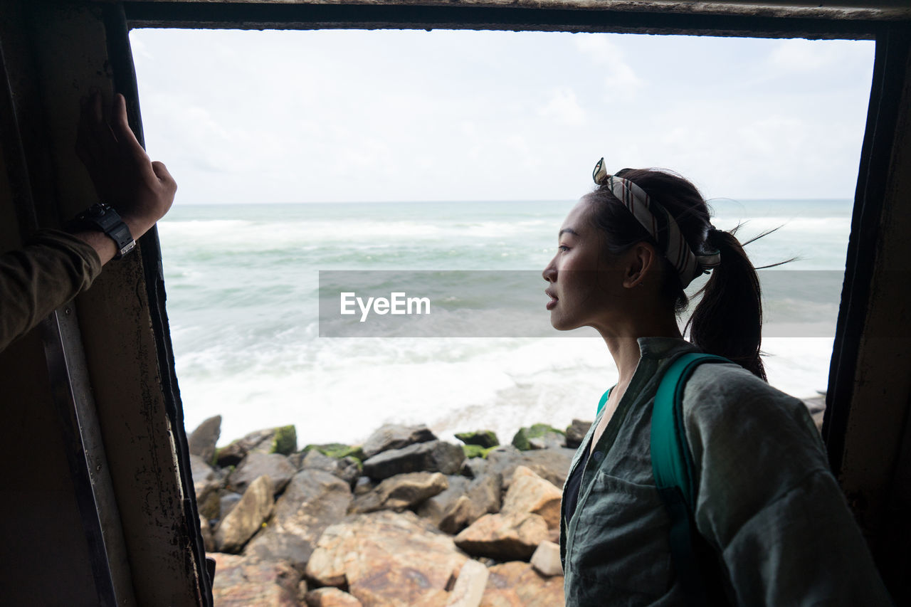 Curious female on vacation travelling by coastal train