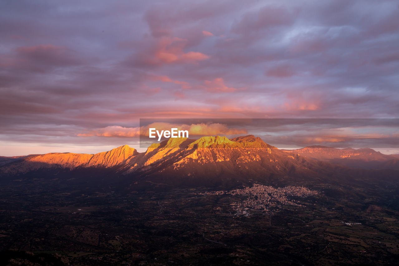 View of landscape against cloudy sky during sunset