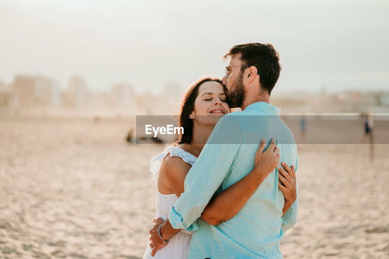 Couple embracing while standing on beach